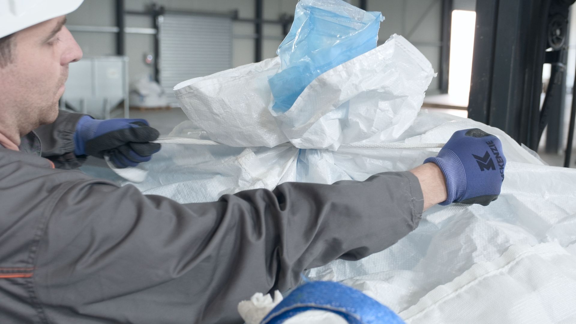 Operatore chiude il beccuccio di riempimento di un Nox Big Bag ermetico per stoccaggio agricolo Operatore chiude il beccuccio di riempimento di un Nox Big Bag ermetico per stoccaggio agricolo